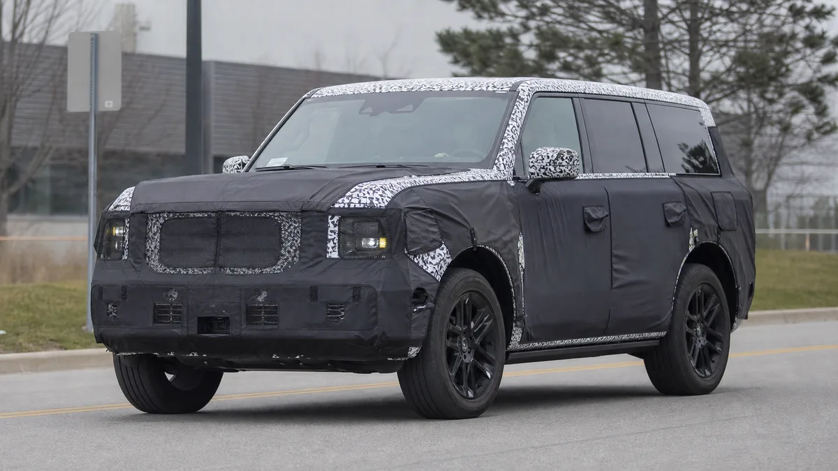 Generated automotive spy-shot style cover showing a camouflaged boxy SUV prototype