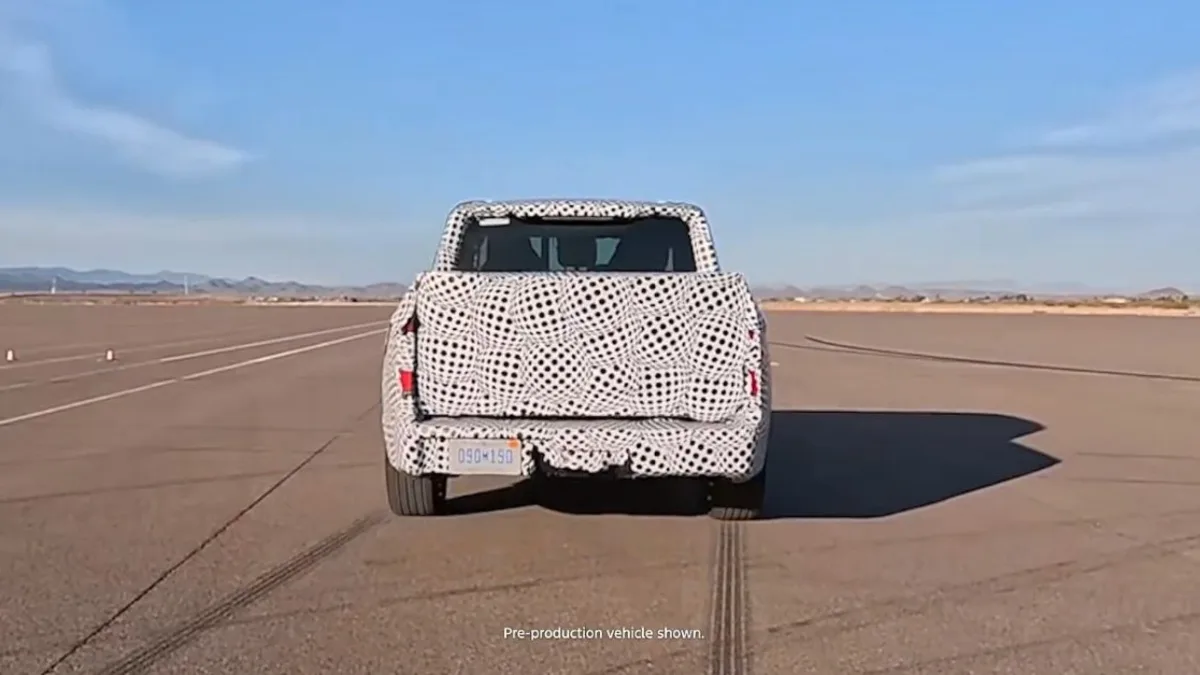 Compact electric pickup truck silhouette beside a charging station