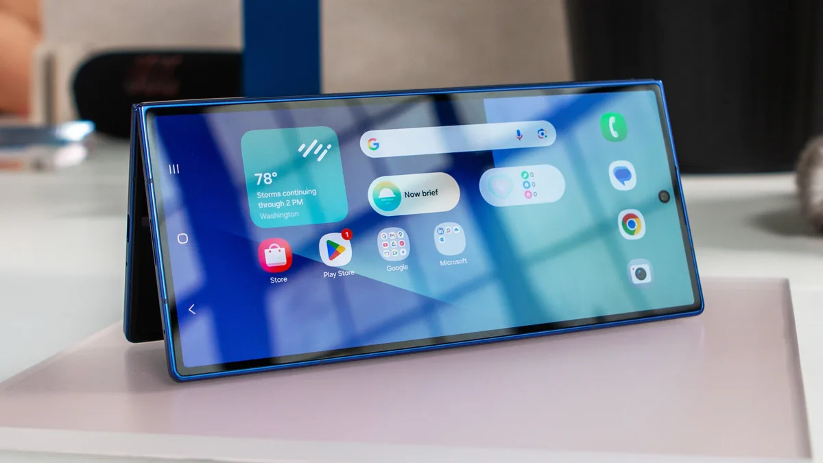 Foldable smartphone opened on a desk beside camera hardware