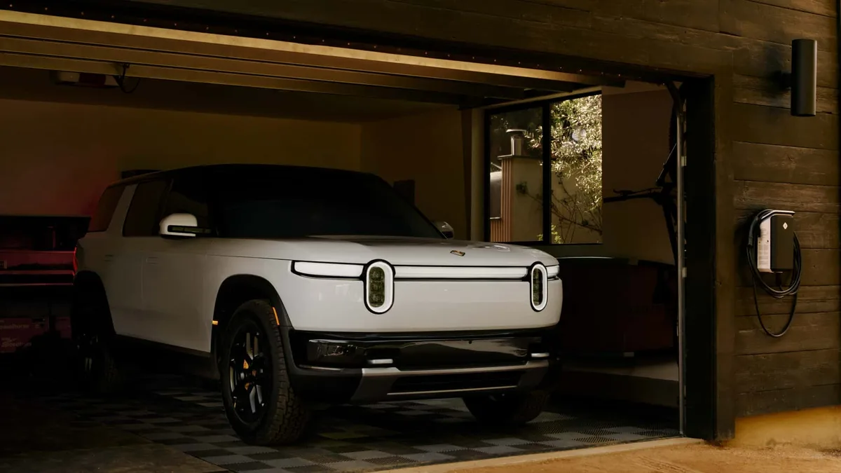 Rivian R2 electric SUV at a charging station with market demand context